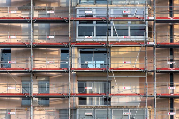 Fassadengerüst an einem mehrgeschossigen Wohnhaus, Lagen über die ganze Gebäudeseite