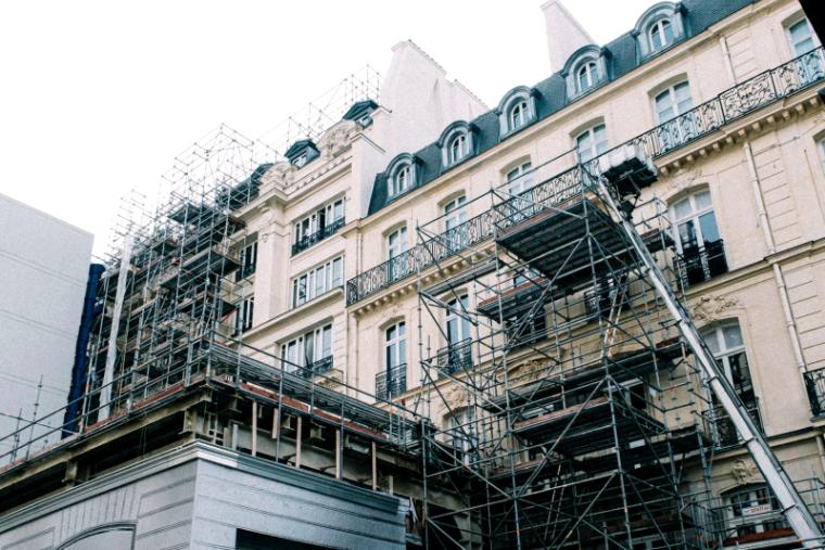 Altbaufassade mit Balkonen und Gerüst über mehrere Geschoße