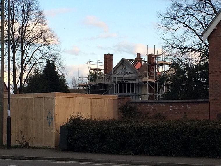 Haus mit abgedecktem Dach und Gerüst bis über den Dachrand